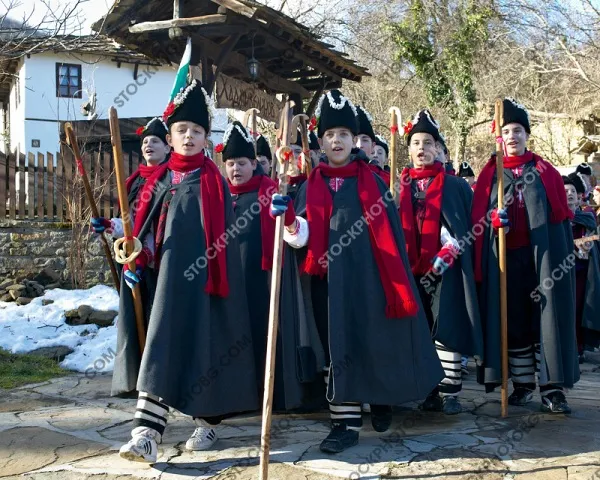 Коледари на фона на възрожденски къщи в село Боженци
